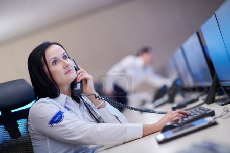 Téléchargez les photos : Opérateur de gardien de sécurité féminin parlant au téléphone - en image libre de droit
