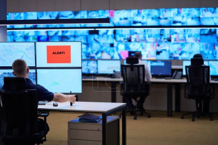 Téléchargez les photos : Jeune opérateur masculin travaillant dans une salle de contrôle du système de données de sécurité - en image libre de droit