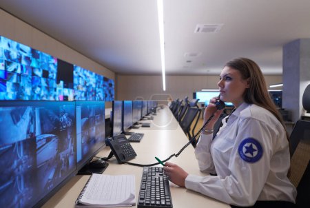 Téléchargez les photos : Opérateur de gardien de sécurité féminin parlant au téléphone - en image libre de droit