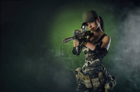 Foto de A soldier girl poses with an automatic rifle - Imagen libre de derechos