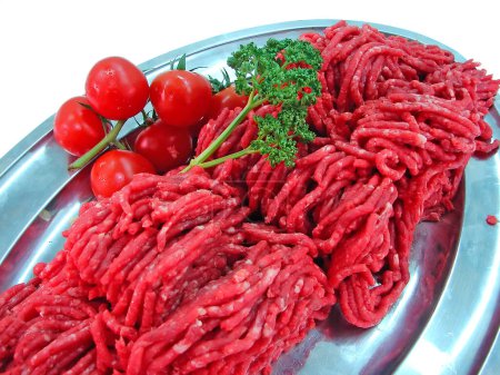 Foto de Carne fresca y tomate en un plato - Imagen libre de derechos