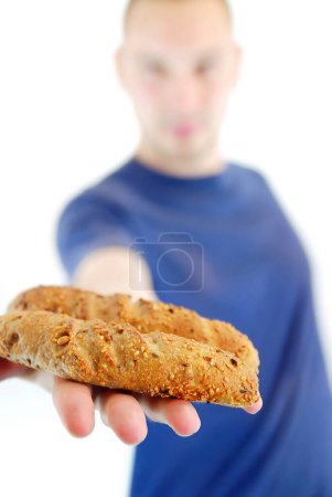 Téléchargez les photos : Homme montrant un petit pain frais à la main, gros plan - en image libre de droit
