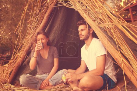 Photo for "couple spending time together in straw tent" - Royalty Free Image