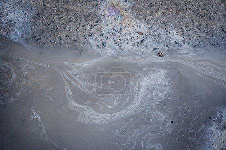 Photo for Gas stain on wet asphalt caused by a leak under a car or truck - Royalty Free Image