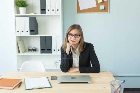 Foto de Concepto de negocios, bienes raíces y personas - Mujer atractiva en la oficina hablando por teléfono y tomar notas - Imagen libre de derechos
