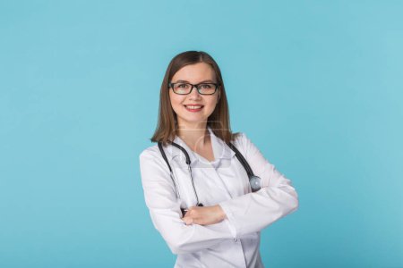 Téléchargez les photos : Portrait de femme médecin sur fond bleu - en image libre de droit