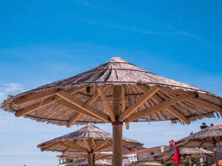 Foto de View of the beautiful blue sky and straw beach umbrellas - Imagen libre de derechos