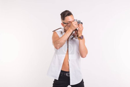 Téléchargez les photos : "Technologies, photographie et concept de personnes - beau jeune homme avec appareil photo rétro sur fond blanc
" - en image libre de droit
