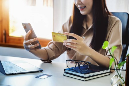 Téléchargez les photos : "Achats en ligne et paiements Internet, belles femmes asiatiques utilisent leurs cartes de crédit et téléphones mobiles pour faire des achats en ligne ou faire des courses dans le monde numérique." - en image libre de droit