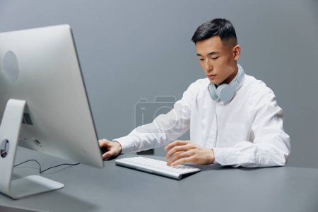 Foto de "hombre en auriculares en la mesa delante de la computadora Estilo de vida trabajo" - Imagen libre de derechos
