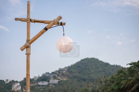 Foto de Polo de bambú y lámpara blanca con cielo azul y montaña verde. - Imagen libre de derechos