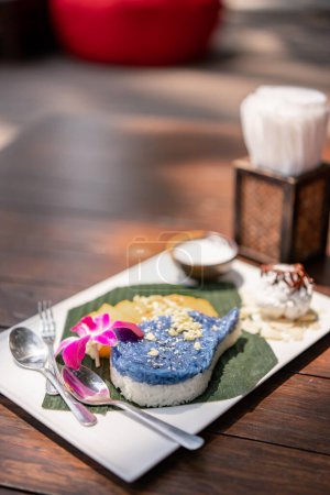 Foto de Arroz azul pegajoso con mango maduro dulce. (Khao Nieow Ma Muang) Postre tailandés. - Imagen libre de derechos