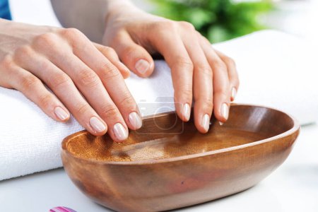 Photo for Closeup female hands in wooden bowl with water - Royalty Free Image