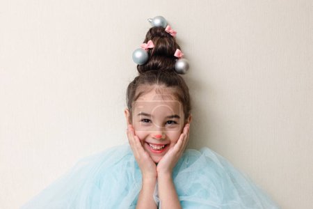 Téléchargez les photos : Portrait de fille drôle avec une coiffure sous la forme d'un arbre de Noël - en image libre de droit