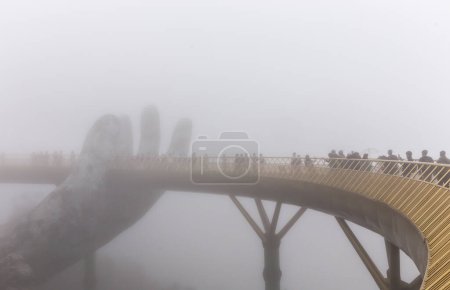 Foto de "Danang, Vietnam - ENERO 04, 2019: Vista en la niebla del puente de oro en las colinas de Ba Na en Da Nang en días lluviosos
" - Imagen libre de derechos