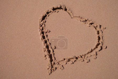 Téléchargez les photos : "Coeur est peint sur le sable de la plage de la mer gros plan" - en image libre de droit
