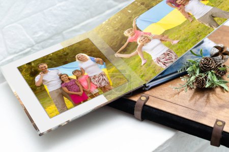 Téléchargez les photos : Archives de photos de famille enregistrées dans le livre photo brillamment conçu souvenirs d'été lumineux placés dans le livre photo. famille avec drapeau de l'ukraine - en image libre de droit