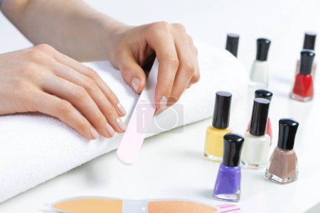 Photo for "Woman using nail file and create nails shape" - Royalty Free Image
