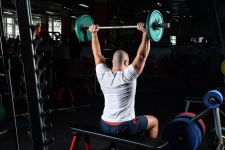 Photo for "Male athlete lifts the barbell" - Royalty Free Image