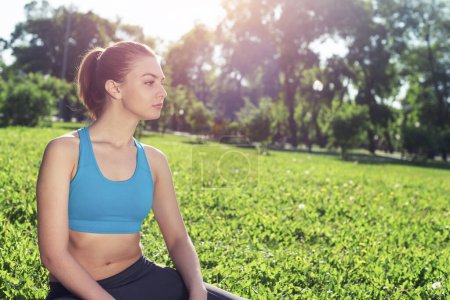 Photo for "Beautiful smiling girl in activewear relax in park" - Royalty Free Image