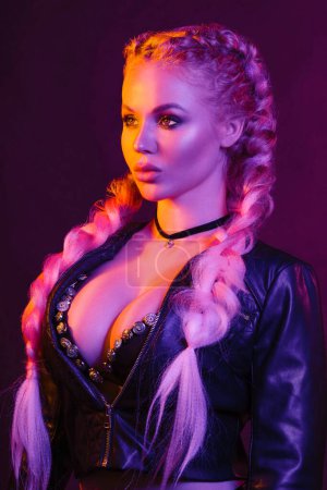 Photo for "Portrait of seductive young European woman surrounded by evening neon lights medium close-up" - Royalty Free Image