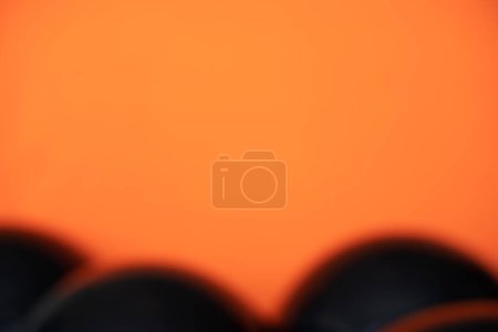 Photo for "simple blurred black balloons on orange background" - Royalty Free Image