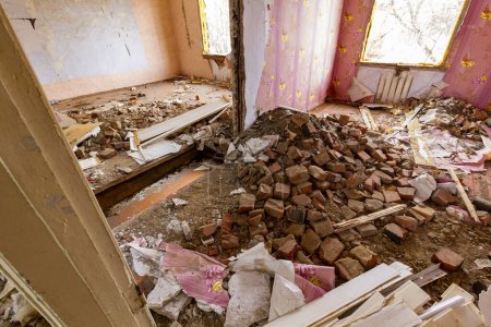 Foto de "Muchos ladrillos cayeron de un agujero en el techo y las paredes de la casa. Destruido por una explosión residencial edificio de apartamentos." - Imagen libre de derechos