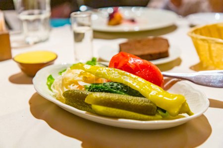 Téléchargez les photos : "Collations russes traditionnelles (cornichons, tomates, choucroute) sont sur l'assiette." - en image libre de droit