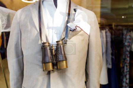 Photo for A fragment of a beige jacket and large vintage binoculars on the chest of a mannequin - Royalty Free Image
