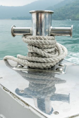 Téléchargez les photos : Poteau d'amarrage sur petit bateau sur belle eau verte - en image libre de droit