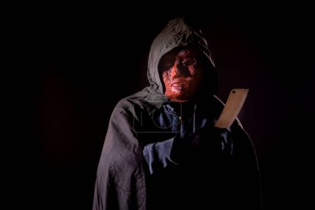 Photo for Scary killer in mask holding knife - Royalty Free Image