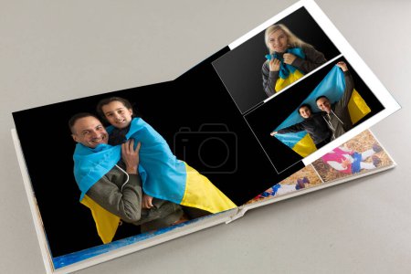 Téléchargez les photos : Archives de photos de famille enregistrées dans le livre photo brillamment conçu souvenirs d'été lumineux placés dans le livre photo. famille avec drapeau de l'ukraine - en image libre de droit