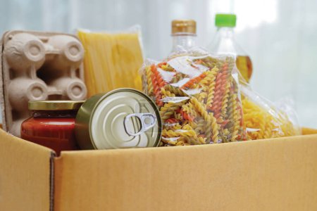 Téléchargez les photos : "Denrées alimentaires dans une boîte de dons pour bénévoles." - en image libre de droit