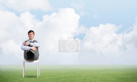 Photo for Scared businessman on a chair - Royalty Free Image
