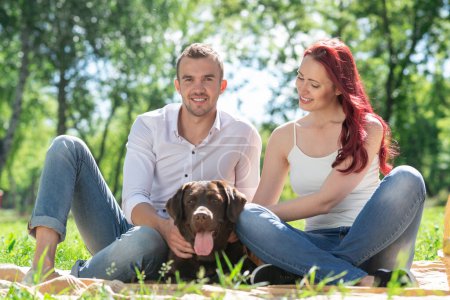 Téléchargez les photos : Couple avec un chien dans le parc - en image libre de droit