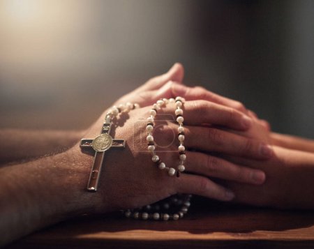 Photo for Seeking guidance from a spiritual leader. Cropped shot of two people praying while holding a rosary. - Royalty Free Image