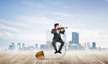 Photo for "Young businessman plays the violin" - Royalty Free Image