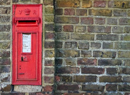 Photo for "A red British post box in a wall with the royal cypher VR" - Royalty Free Image