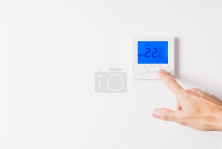 Photo for "hand adjusting the temperature of a thermostat" - Royalty Free Image