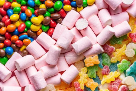 Photo for Close-up of gummies, colored chocolate balls and marshmallows placed in three diagonal lines occupying the entire horizontal image - Royalty Free Image