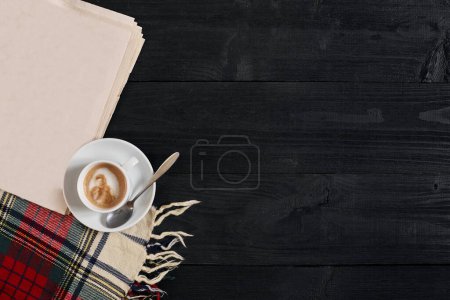 Foto de "Espacio de trabajo con periódico, taza de café, bufanda. Elegante escritorio de oficina. Concepto de otoño o invierno. Piso tendido, vista superior
" - Imagen libre de derechos