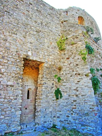 Foto de "Las ruinas de una antigua fortaleza. viejos muros de piedra gruesa de una fortaleza europea cubierta de vegetación en las montañas. Puertas y arcos en las ruinas de las fortificaciones" - Imagen libre de derechos