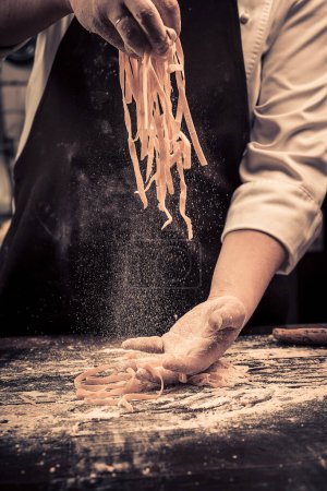 Photo for "The chef makes fresh spaghetti from scratch." - Royalty Free Image