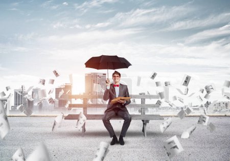 Photo for "young businessman with an umbrella and a book" - Royalty Free Image