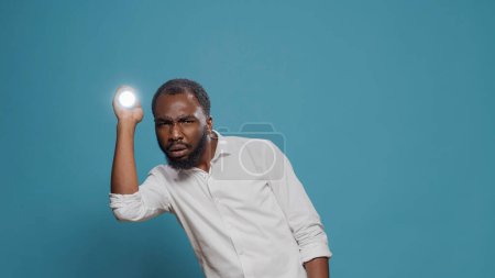 Foto de Hombre asustado usando linterna para hacer luz y mirar a su alrededor - Imagen libre de derechos