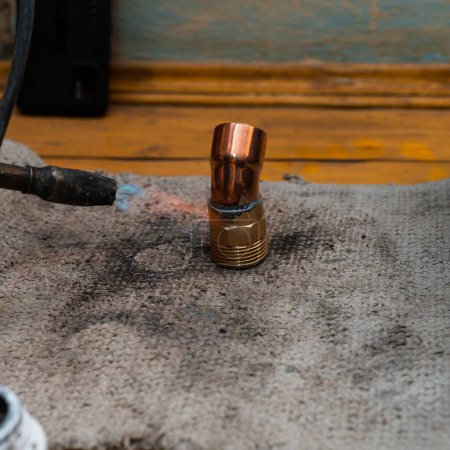 Foto de Soldadura de cobre, proceso de trabajo de instalación y soldadura de tubos de cobre a la chimenea de calefacción. - Imagen libre de derechos
