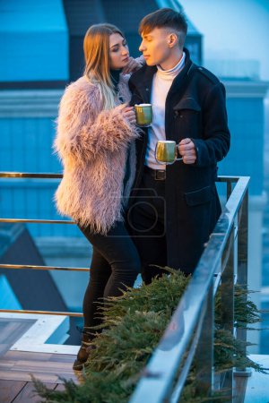 Photo for Couple with mugs on the terrace of a high-rise building - Royalty Free Image