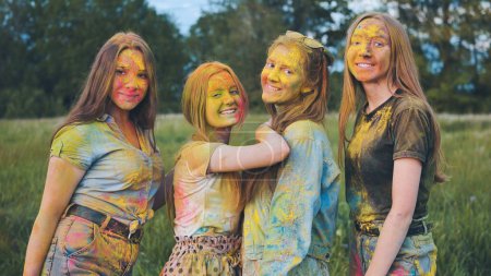 Téléchargez les photos : "Filles gaies posant enduit de poudre multicolore." - en image libre de droit