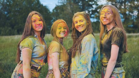 Téléchargez les photos : "Filles gaies posant enduit de poudre multicolore." - en image libre de droit