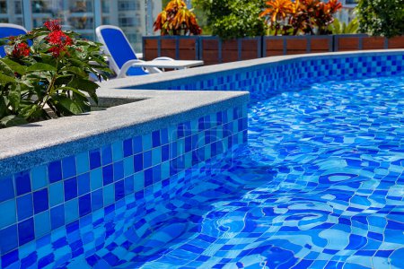 Téléchargez les photos : "Zone récréative de piscine d'hôtel avec l'eau bleue
" - en image libre de droit